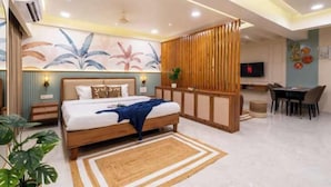 A modern bedroom with a bed, a desk, and a TV. - Tarashi homes (Candolim)