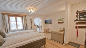 Un dormitorio con una cama grande, un sofá, un televisor y techo de madera.