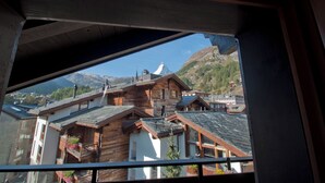 Ein Blick auf traditionelle Holzhäuser mit geneigten Dächern, vermutlich ein Teil eines Bergdorfs.