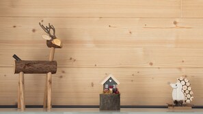 A wooden wall with a rustic decor including a deer, a small house, and a bear figure. - Zardin 7 (Valdidentro)