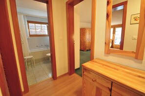 A bathroom with a wooden vanity, a mirror, and a window. - Haus Dent Blanche, Apartment Pollux (Zermatt)
