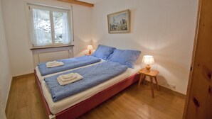 Una camera da letto con un letto matrimoniale, due abat-jour, una finestra e un quadro appeso al muro.
