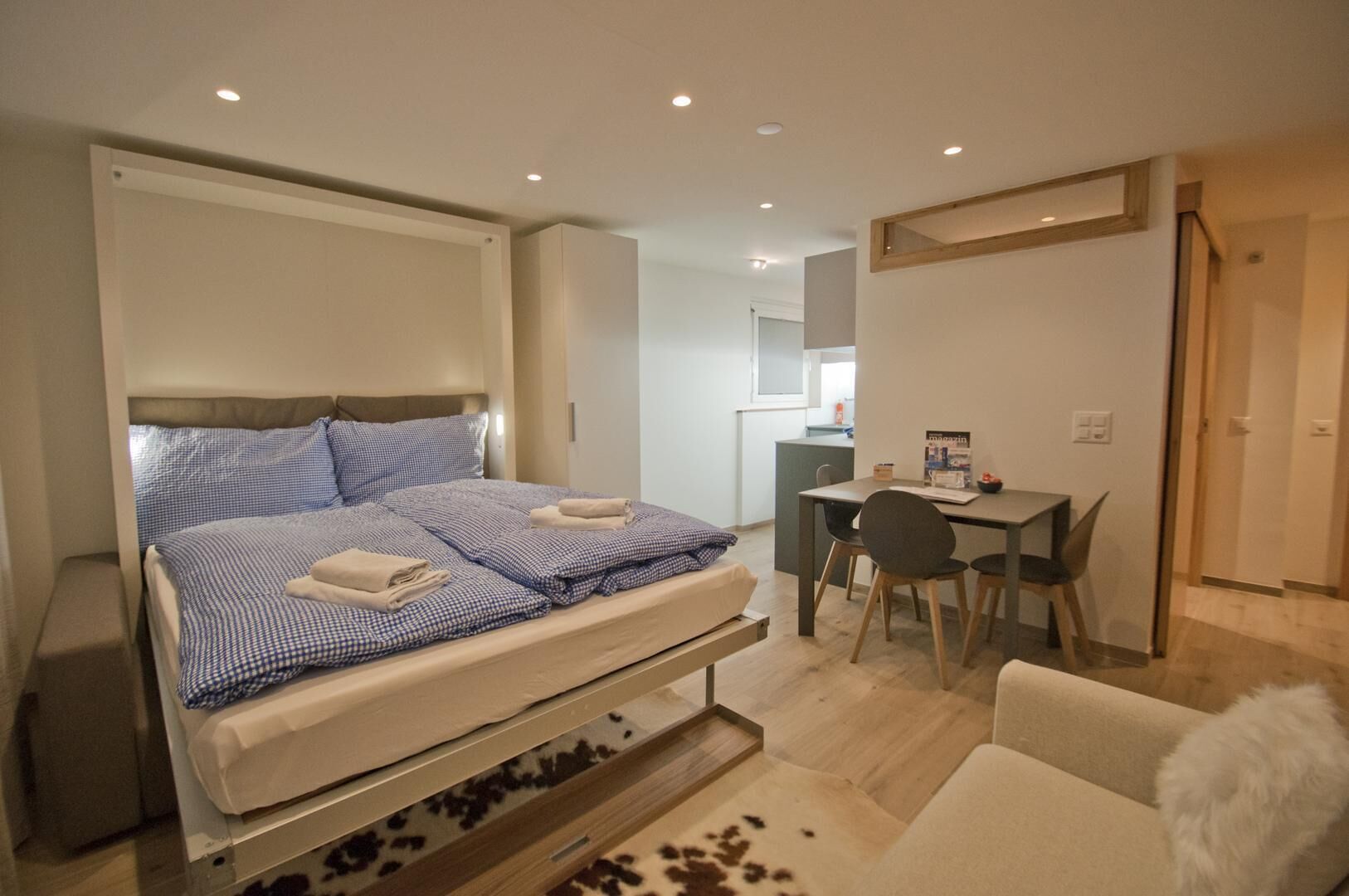 Un dormitorio moderno con cama, escritorio y silla.