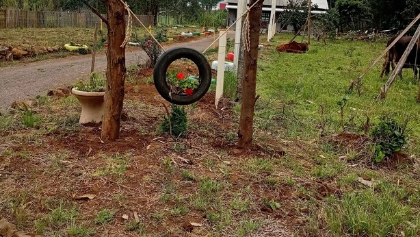 Une enseigne rustique en bois portant l’inscription « CANTINHO DA ANE » dans un cadre rural.