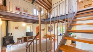 A spacious living area with a wooden staircase, a fireplace, and a dining area. - Charming villa in Crestatx, near Pollensa (Sa Pobla)