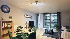 Un salon moderne avec un coin repas, de grandes fenêtres et une vue sur la ville.