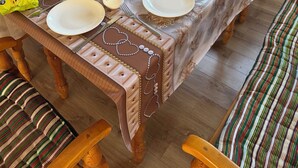 Une table à manger dressée avec des assiettes, des bols et divers aliments, entourée de chaises en bois dotées de coussins à rayures.