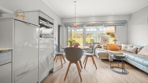 Una cocina moderna con comedor, sofá y vistas al exterior.