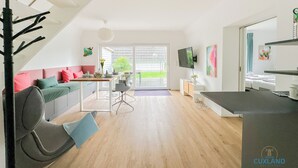 Eine moderne Wohnung mit Treppe, Essbereich, Wohnzimmer und Küche.