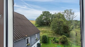 A house with a sloped roof and a well-maintained lawn. - Double Room with Shower/WC (Kirchhundem)