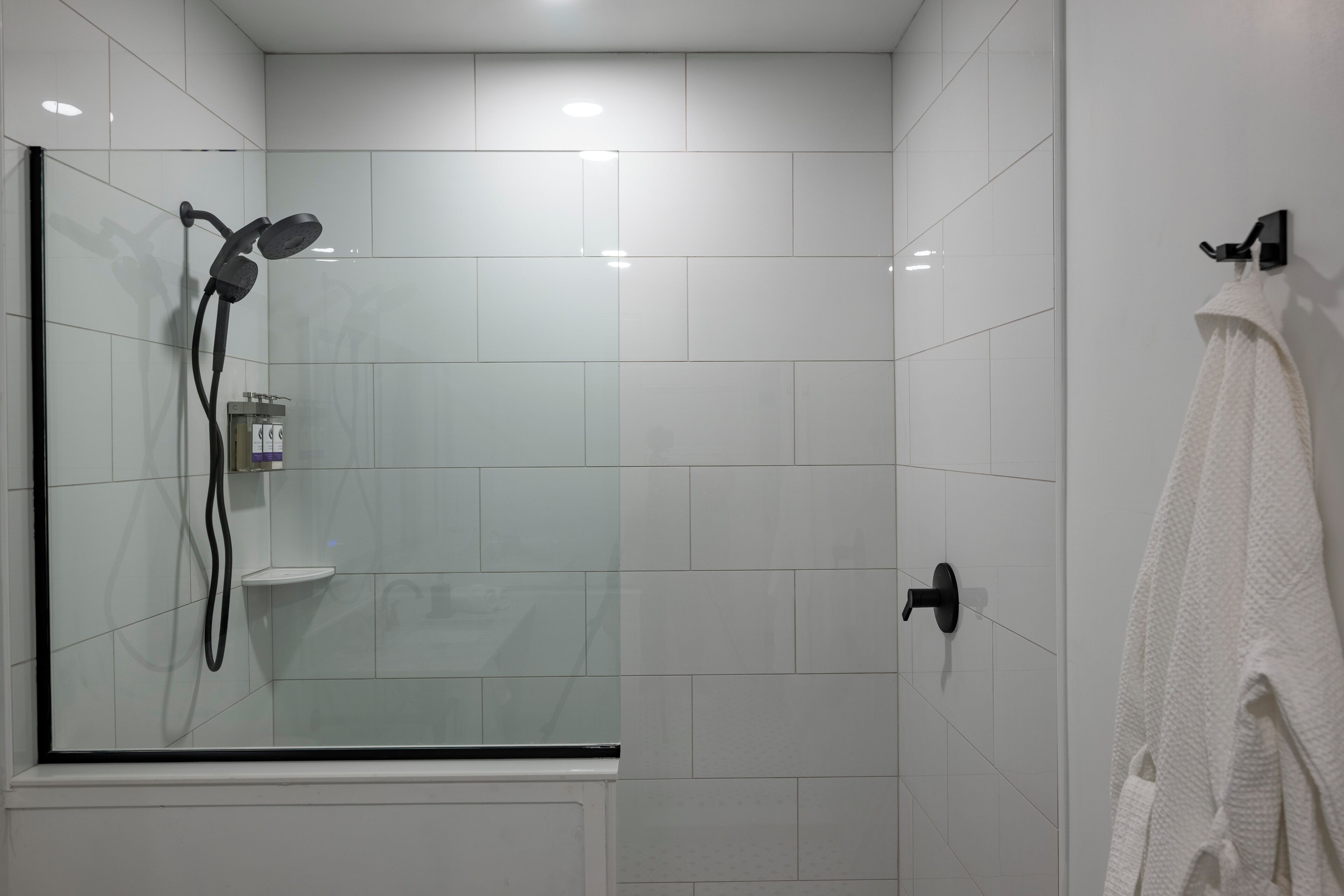 Un baño moderno con cabina de ducha de vidrio, un toallero blanco y una toalla blanca.