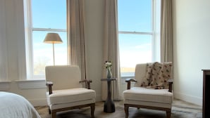 A room with two armchairs, a small table with a vase, and a lamp. - Hotel Thoroughbred (Paris)
