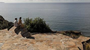 A stone pathway leading to a seating area overlooking a body of water.