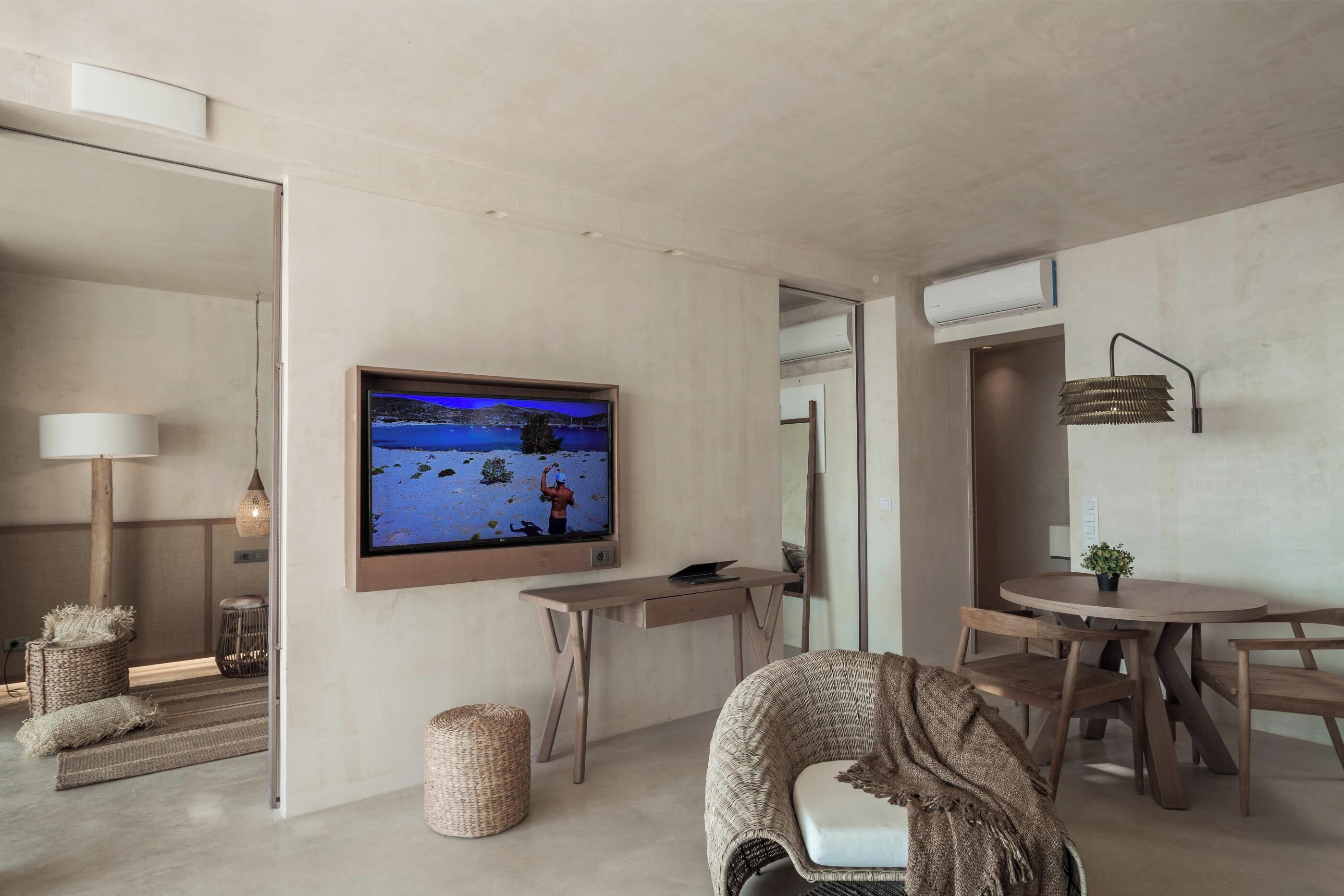 Een moderne woonkamer met een flatscreen televisie, houten meubels en een gezellige zithoek.