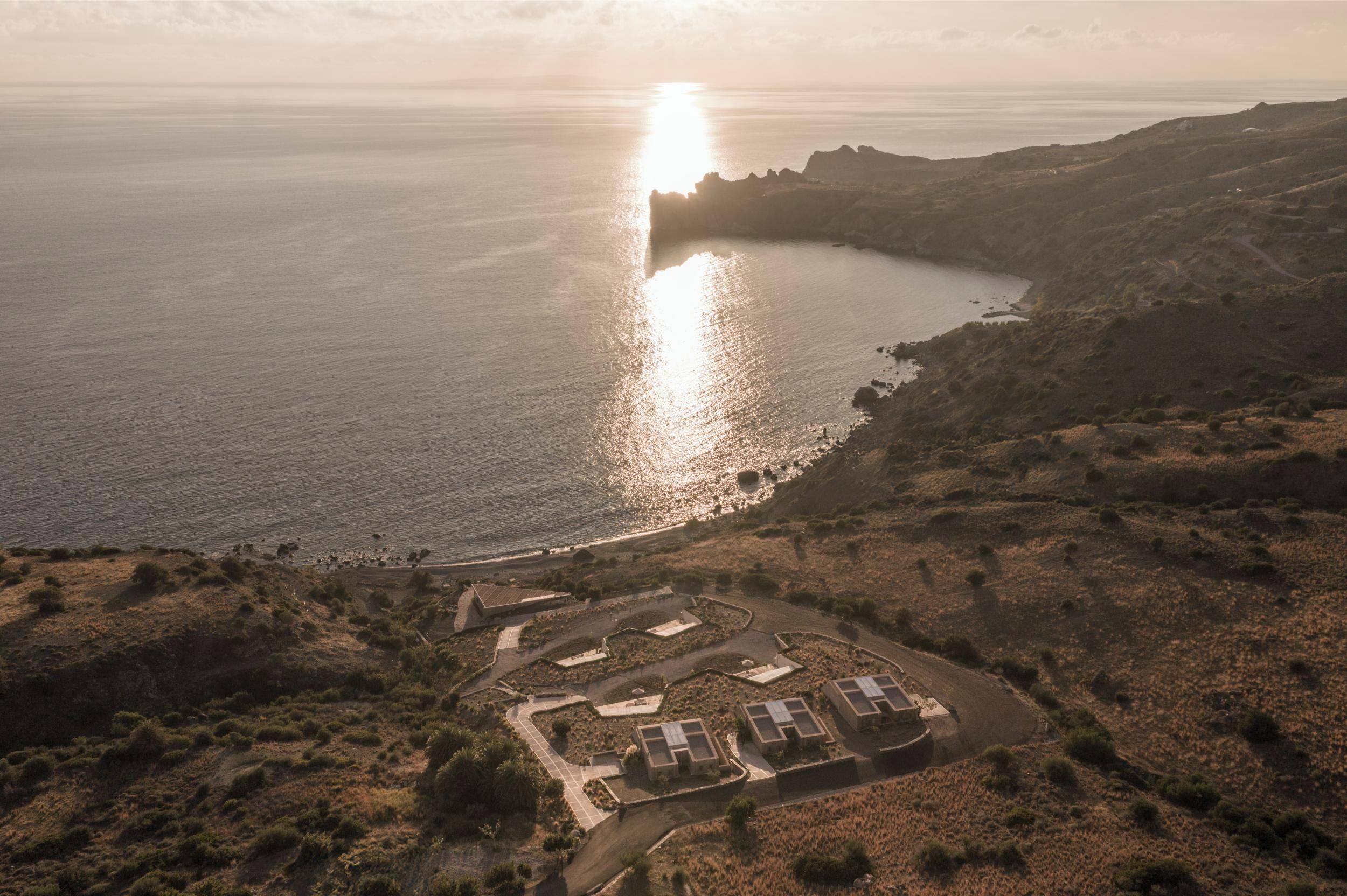 Vue aérienne d’une zone côtière avec des bâtiments, une route et une plage.