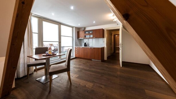 Una cocina moderna con armarios de madera y una zona de comedor con mesa y sillas.
