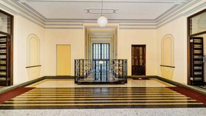 A spacious lobby with a central staircase, a chandelier, and a patterned floor. - Central Milan Apartment - 10 min Duomo (Milan)