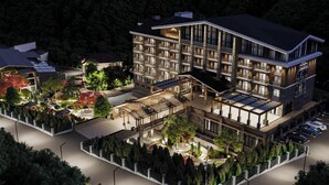 A multi-story hotel with a modern design, featuring a covered outdoor area with seating and a landscaped garden. - Zamindor Resort (Zaamin)