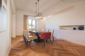 A dining area with a round table, chairs, and a hanging light fixture. - Apartments Florence - The Four Suites (Firenze)