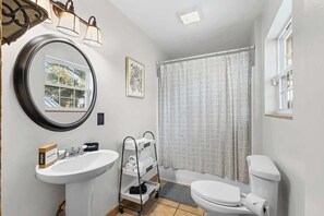 Ein Badezimmer mit Waschbecken, Toilette und Duschvorhang.