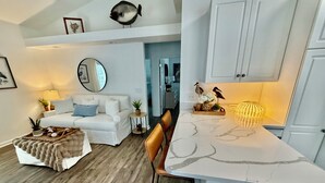 A modern living room with a white sofa, a coffee table, and a dining area with a white table and chairs. - Z35 Absolutely beautiful 2 bedroom 2 bath Ocean Lakes! (Myrtle Beach)