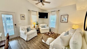 A living room with white furniture, a ceiling fan, and a TV mounted on the wall. - Z35 Absolutely beautiful 2 bedroom 2 bath Ocean Lakes! (Myrtle Beach)