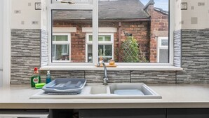 A kitchen with a window, a sink, and a dish rack. - Stoke Work Stay - Contractors & Families - Sleep 6 (Stoke-on-Trent)