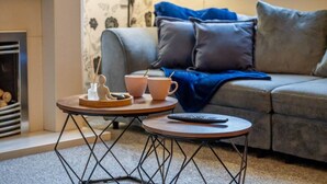 A cozy living room with a sofa, a coffee table, and a fireplace. - Stoke Work Stay - Contractors & Families - Sleep 6 (Stoke-on-Trent)