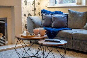 A cozy living room with a sofa, a coffee table, and a fireplace. - Stoke Work Stay - Contractors & Families - Sleep 6 (Stoke-on-Trent)
