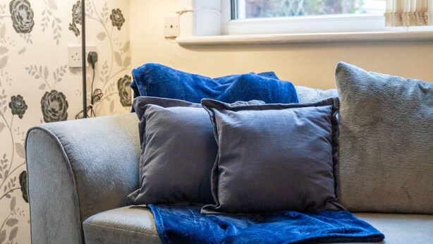 A sofa with a blue blanket and two pillows. - Stoke Work Stay - Contractors & Families - Sleep 6 (Stoke-on-Trent)