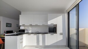 Eine moderne Küche mit weißen Schränken, einer Mikrowelle und einem Backofen.