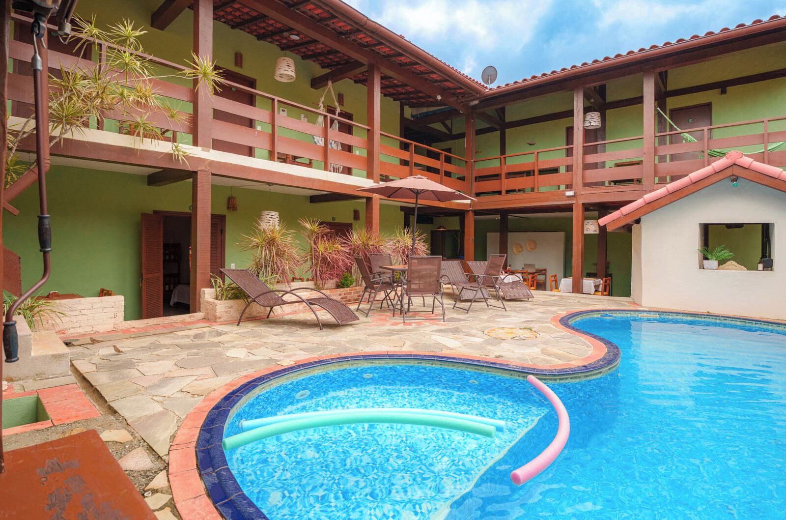 Una piscina al aire libre, sombrillas, tumbonas