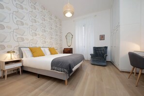 Ein Schlafzimmer mit Bett, Nachttisch, Stuhl und Kleiderschrank.