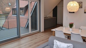 En modern lägenhet med balkong, matplats och kök.