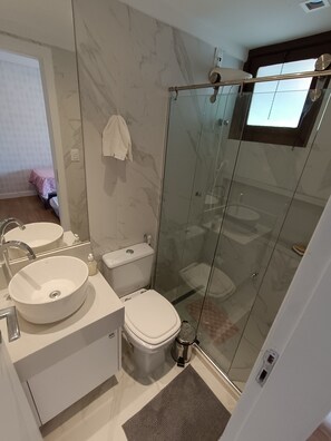 Een douche, handdoeken, zeep, toiletpapier
