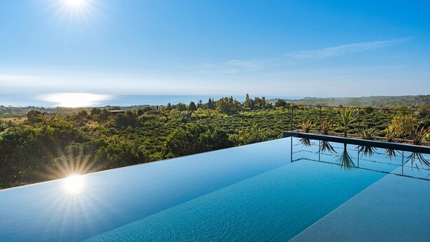 An infinity pool with a clear view of the ocean and surrounding greenery. - Villa with pool and breathtaking view - DiCasaInSicilia (Santa Venerina)