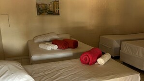 A hotel room with two single beds, a large bed, and a painting on the wall. - Pousada Rota do Parque (Penha)