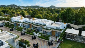 Ein Wohnkomplex mit mehreren Gebäuden, Außenbereichen zum Sitzen und Grünflächen.
