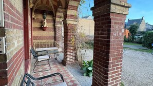 A covered outdoor seating area with brick arches and checkered flooring. - La Villa Bligny (Étretat)