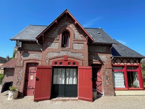 A traditional brick building with a red door and window frames, a gabled roof, and a small porch area. - La Villa Bligny (Étretat)