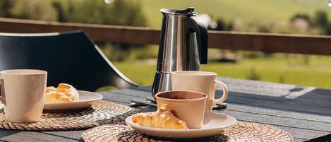 A table set outdoors with a view of a green landscape.