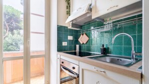 Uma cozinha com pia, forno e armários.