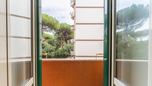 Uma varanda com vista para árvores e um edifício.