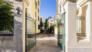 A narrow street with a cobblestone path leading to a gated entrance. - Testaccio Patty Flat (Rome)