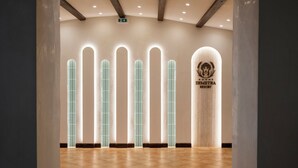A hotel lobby with a tiled floor, a reception desk, and a logo on the wall. - Villa Demetra Resort (Agrigento)