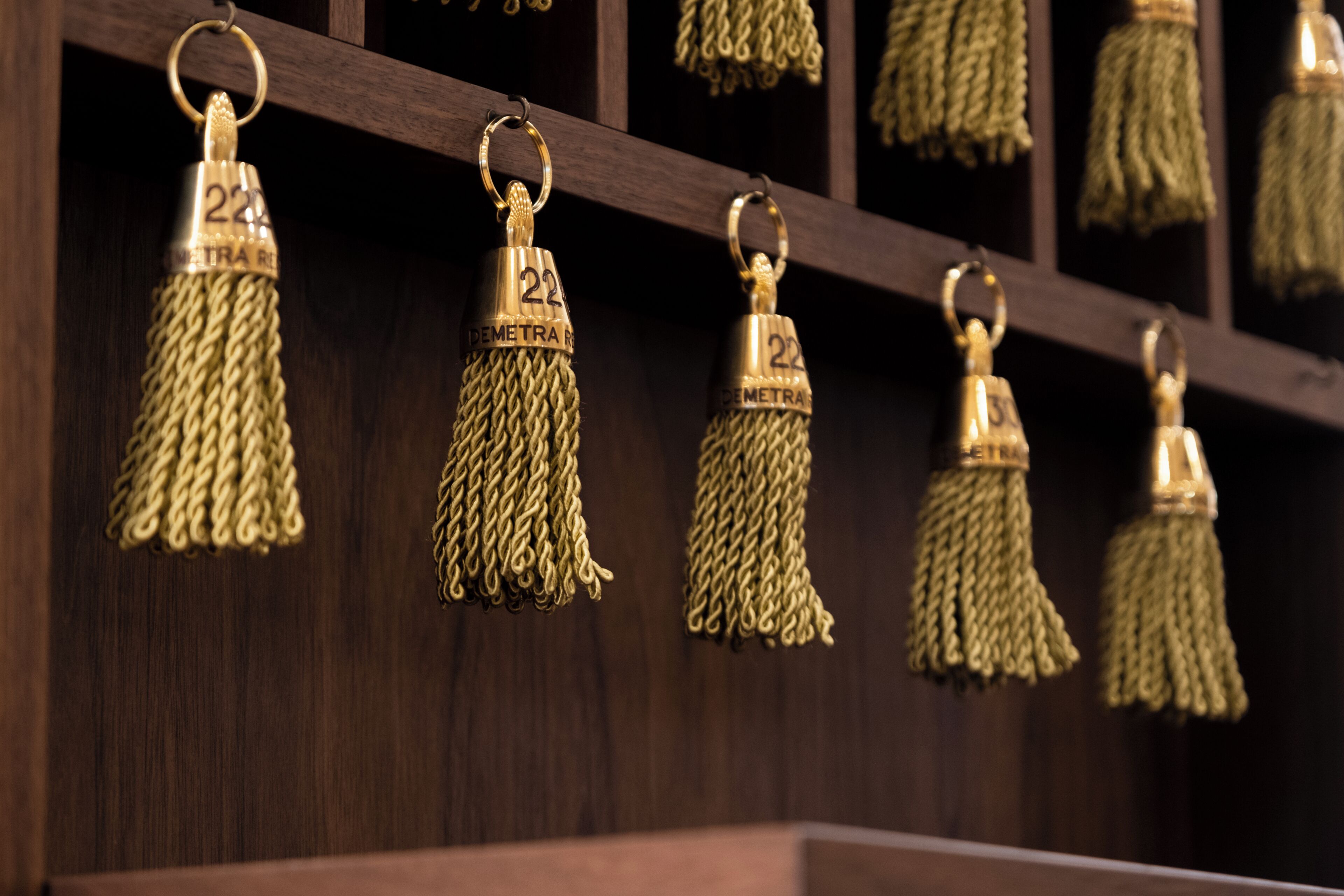 A series of golden tassels with the number '22' hanging from a wooden structure.