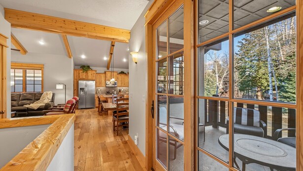 Eine geräumige Küche mit Holzausstattung und einem großen Fenster mit Blick auf eine Terrasse.