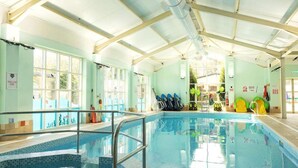 An indoor swimming pool with clear water, a metal pool ladder, and several diving boards. - Host & Stay | Cosy Cove (Cresswell)