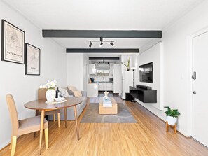 Ein modernes Wohnzimmer mit Essbereich, Küche und einem Flachbildfernseher.