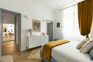 A modern bedroom with a bed, a dresser, a mirror, and a door leading to a dining area. - Belle epoque house of mirror (Roma (RM))